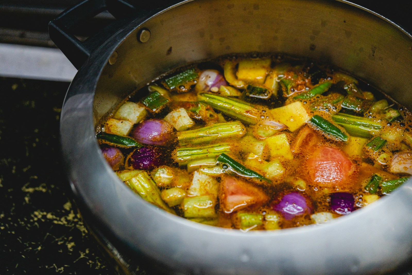 A pot filled with vegetables sitting on top of a stove