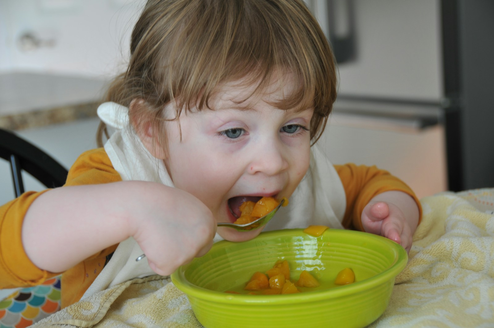 child in white shirt eating